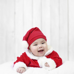 asian children cute or kid and baby wearing santa claus suit with fun or happy and smile in the winter on white wood wall background for christmas or xmas and happy new year with space