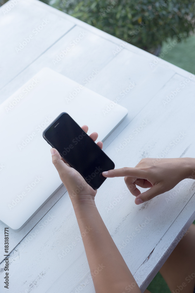 Aufkleber hand using smart phone on desk vertical view