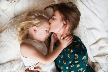 Happy   family mother and her daughter child girl playing,  hugging  and spending time at home.