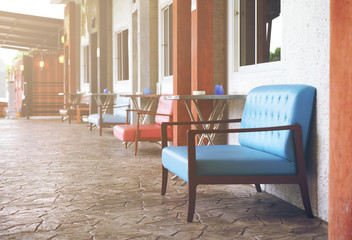 front room blue and red color chair or sofa on walkway or pathway and terrace on street for relax with smoking zone exterior at cafe restaurant on warm sunlight and vintage style