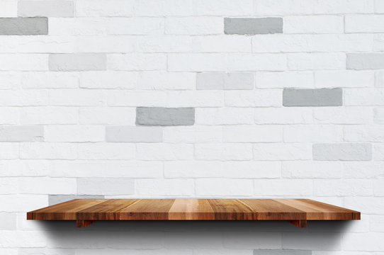 Empty wood plank shelf at clean white brick wall background,Mock up for display or montage of product or design