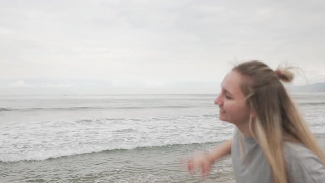 teen girl posing on Santa Monica beach in cloudy november day shot with gimbal