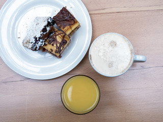 Coffee with milk, orange juice and cake