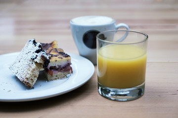 Coffee with milk, orange juice and cake