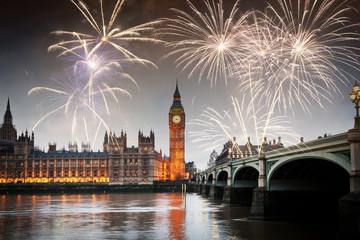 Naklejka premium explosive fireworks display fills the sky around Big Ben. New Year's Eve celebration in the city