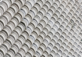 Facade of a high-rise house with many half-round balconies. Diagonal Line of circular balconies on white skyscraper.