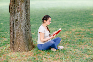 Beautiful pregnant woman relaxing in the park.