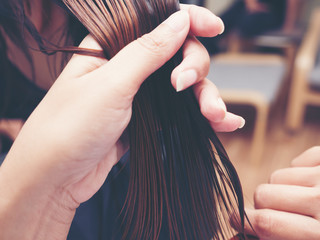 Close up of hairdresser hand giving a new haircut to female customer at parlor