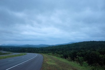 A highway bends toward the foothills on a cloudy late summer morning just before sunrise near Anniston, Alabama, USA