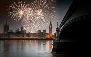 Fototapeta na wymiar explosive fireworks display fills the sky around Big Ben. New Year's Eve celebration in the city