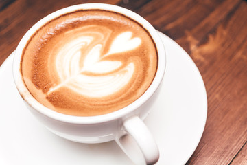 Coffee latte art on wooden table in coffee shop