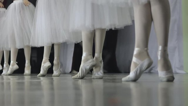 Ballet.Close-up of a girl's legs in white ballet shoes during ballet training. Element of classical dance. 4K