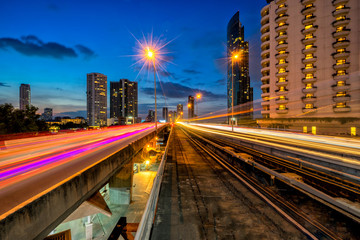 Fototapeta na wymiar Sunset scence of Bangkok Panorama skyline ,Aerial view of Bangkok modern office buildings and condominium in Bangkok city downtown with ligt trail of car on road at Bangkok , Thailand. And skytrain