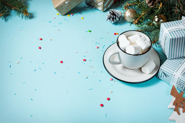 Winter hot drink. Christmas hot chocolate or cocoa with marshmallow on blue background with...