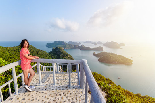 Woman tourist on the balcony is peak view point of Ko Wua Ta Lap island and beautiful nature landscape during sunrise over the sea in Mu Ko Ang Thong National Park, Surat Thani, Thailand