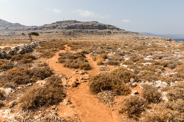 Fototapeta na wymiar Stony landscape on the way to the Kleoboulous's tomb in Lindos on the Rhodes Island, Greece. 
