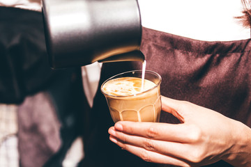 Barista holding milk for make coffee latte art in coffee shop