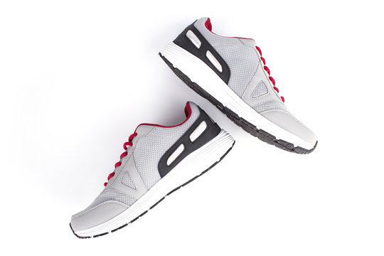 Gray sneakers with red laces on a white background