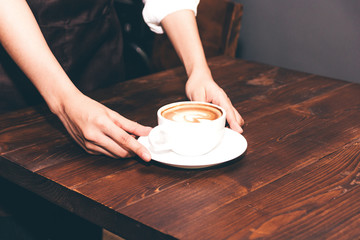 Barista holding coffee latte art in coffee shop