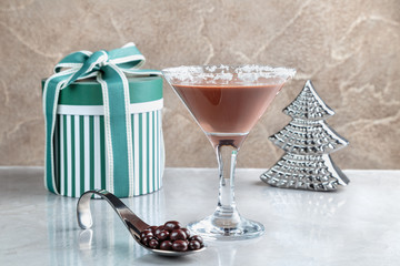 chocolate shake in a glass with a high stem on the background of gift boxes with bow