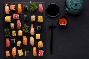 Set of sushi maki and rolls on black background