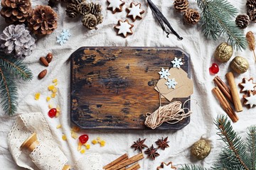 Christmas decoration with rustic cutting board, fir, cones and spices. Overhead view