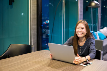 Beautiful Asian girl celebrate with laptop, using hands in different positions, education or technology or startup business concept, modern office or living room with copy space