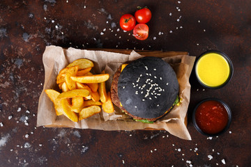 Black bun burger with potato wedges top view