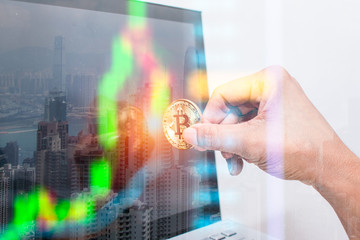 Double exposure. hand holding Electronic money golden bitcoin to the computer or laptop. with Stock Exchanges table. With City and bay on the Blurred background. Modern business concept.