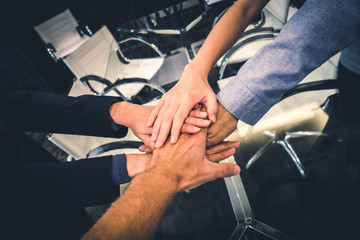 Business partners teamwork or friendship concept. Multi-ethnic diverse group of colleagues join hands together. Creative team, coworkers, or college students in project meeting at modern office