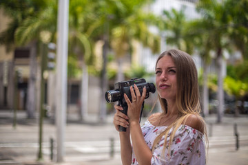 Tenerife. Spain. Cute blonde girl is observing and  filming streets in Santa Cruz de Tenerife. Girl travels concept. Travel to Canary Islands.