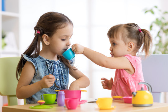 Kids playing with plastic tableware