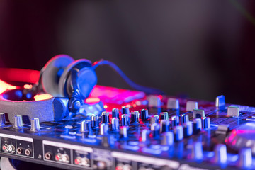 The DJ console cd mp4 deejay mixing desk Ibiza house music party in nightclub with colored disco...