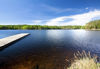 Wooden pier on beautiful lake in the national park Repovesi, Finland, South Karelia.