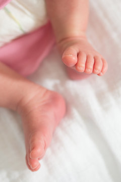 Baby girl legs on white blanket