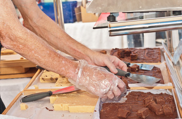 Man cutting hand made fudge / Man cutting hand made fudge at an open air, tropical  farmers market