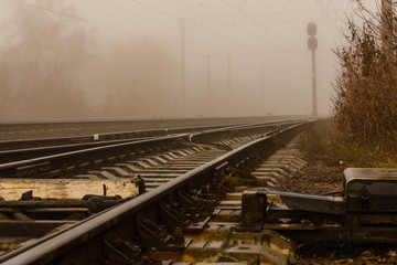 Railroad tracks in the fog on autumn