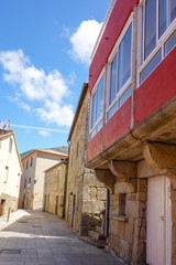Red house facade by medieval city street during sunny day
