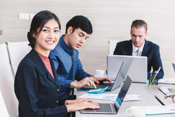 Businesspeople using laptops and discussing together in meeting room.Teamwork concept