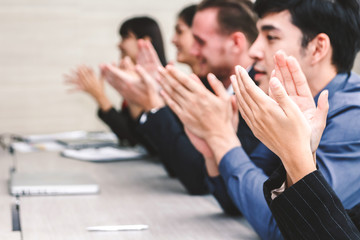Successful business people clapping hands in the meeting