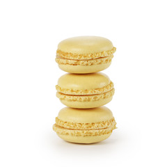 three yellow lemon macarons isolated on white
