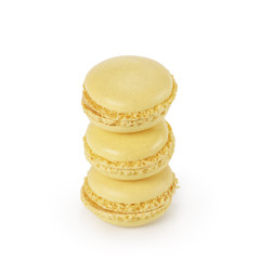 three yellow lemon macarons isolated on white