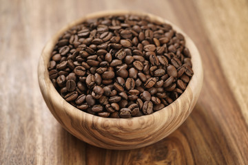 fresh roasted coffee beans in wood bowl on table