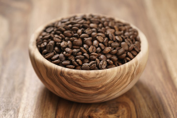 fresh roasted coffee beans in wood bowl on table