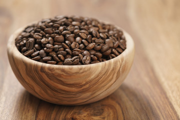 fresh roasted coffee beans in wood bowl on table