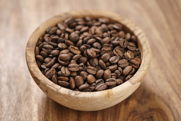 fresh roasted coffee beans in wood bowl on table