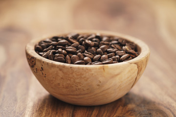 fresh roasted coffee beans in wood bowl on table