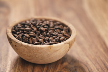 fresh roasted coffee beans in wood bowl on table