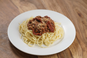 spaghetti bolognese on white plate on wood table