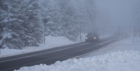 Auto fährt bei Nebel im Winter